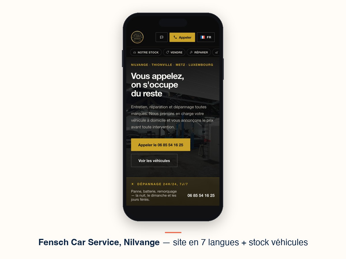 Le site de Fensch Car Service affiché sur un téléphone : page d'accueil du garage à Nilvange, avec le sélecteur de langue, le bouton d'appel et l'accès au stock de véhicules.